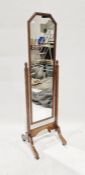 Oak cheval mirror, shaped rectangular with foliate border, on castors, 143cm high approx. overall