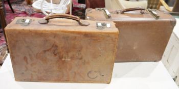 Two vintage brown leather suitcases and a box of assorted linen