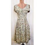 A mid twentieth century day dress, possibly silk, floral pattern, sleeveless but with cap sleeves