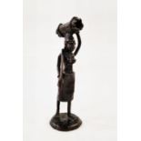 Bronze figure of an African woman carrying wood on her head, unsigned, 26cm high