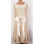 A vintage lace cocktail dress, labelled 'Fur Coat and No Knickers', pale beige lace with big satin