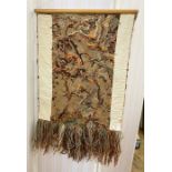 A wall hanging of a multitude of wools and strings in knitting, stitching and knotting, creating a
