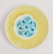 Ruskin pottery circular wall plate with yellow and green crystalline glaze, with central stylized