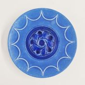 Ruskin pottery circular wall plate with blue matte glaze, with central stylized alternating