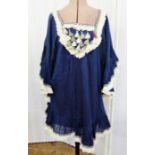 A blue cotton dress angel sleeves, the cuffs and bodice decorated with ethnic tassels and braiding