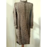 A Persian lamb full length brown coat, collarless, lining has been replaced with a jazzy