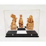 Three contemporary Chess Piece dragons on painted square stand in Perspex box, 17cm wide x 13.5cm