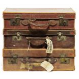 Three vintage leather suitcases, one bearing labels 'Hotel Savoir' and other labels (3)