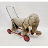 Merrythought elephant on wheels, grey and cream plush with bell, chrome handle, on red metal base,