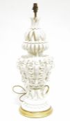 Ornate white ceramic table lamp with applied decoration of leaves and roses, on a circular stepped