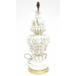 Ornate white ceramic table lamp with applied decoration of leaves and roses, on a circular stepped