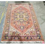 Large eastern style red ground rug with large central floral filled geometric medallion on floral