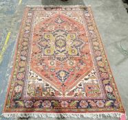 Large eastern style red ground rug with large central floral filled geometric medallion on floral