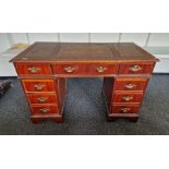Modern pedestal desk with brown leather inset top, an arrangement of drawers around the kneehole,