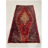 Eastern red ground rug with large central geometric medallion on floral and geometric shaped