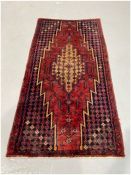 Eastern red ground rug with large central geometric medallion on floral and geometric shaped