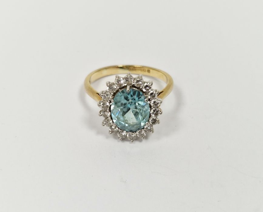 18ct gold yellow gold, diamond and blue stone ring, the oval central stone aquamarine in colour