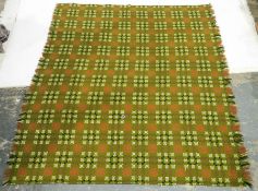 Large Welsh wool blanket decorated with red, black and white geometric decoration, on a green