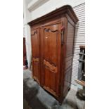 Early 20th century oak two-door wardrobe enclosing hanging space and shelves, on scroll feet (