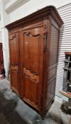 Early 20th century oak two-door wardrobe enclosing hanging space and shelves, on scroll feet (
