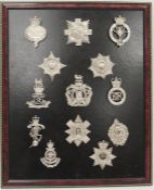 Collection of chrome military badges, mounted to a wooden frame, including the Life guards, thirteen