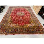 Eastern red ground carpet with central floral medallion on floral field with floral spandrels,