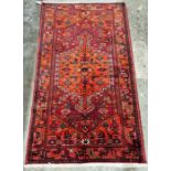 North west Persian red ground Zanjan rug with central hooked geometric medallion enclosing floral