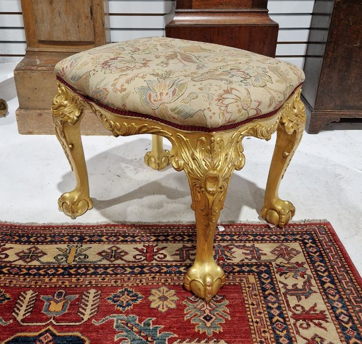 Gilt stool with serpentine sides, on ornate scroll cabriole supports, claw and ball feet Condition