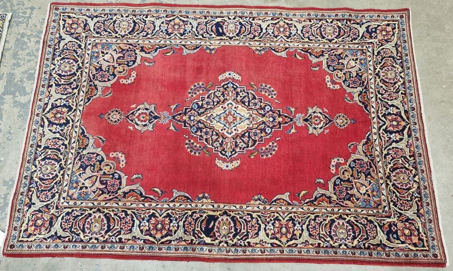 Central Persian red ground Kashan rug with central floral medallion, floral spandrels and multiple