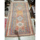 Eastern red ground rug with four lozenge shaped geometric medallions on geometric shape field,