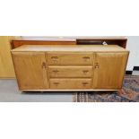 Mid century blonde Ercol sideboard comprising three drawers of graduating form, flanked on either