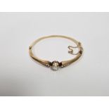 Gold and diamond set bangle, the central old cut diamond 6mm diameter approx., flanked by five