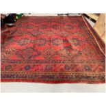 Large square red ground carpet with three rows of five and two rows of four geometric medallions,