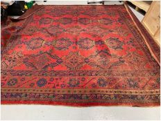 Large square red ground carpet with three rows of five and two rows of four geometric medallions,