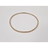 Twisted gold-coloured metal bangle, 6.5g approx. Condition ReportThis bangle tests as 9ct gold or
