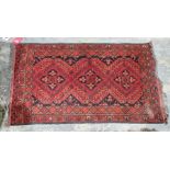 Eastern red ground rug with three central geometric medallions on floral field, multiple floral