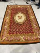 Large Aubusson red ground rug with central M motif on oval medallion over geometric field, single