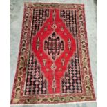 North west Persian red ground Mazlaghan rug with central geometric medallion on geometric shape