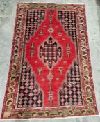 North west Persian red ground Mazlaghan rug with central geometric medallion on geometric shape