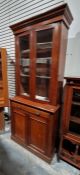 20th century mahogany bookcase with glazed cupboard above enclosing four shelves, drawer and panel