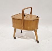 Mid 20th century German teak sewing box with twist top, on splayed supports and castors, 63cm high x