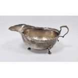 LOT WITHDRAWN Early 20th century silver sauceboat with scroll-shaped handle, on three spade feet,
