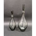 Two 1960's smoked glass decanters and stoppers in sizes, each of baluster form with elongated