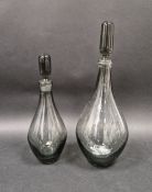 Two 1960's smoked glass decanters and stoppers in sizes, each of baluster form with elongated