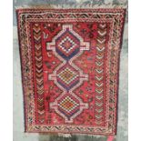 Eastern style red ground rug with three central joint geometric medallions on geometric field,