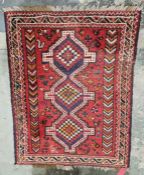 Eastern style red ground rug with three central joint geometric medallions on geometric field,