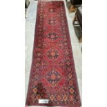 Eastern red ground runner with five central floral medallions on floral field with multiple floral