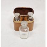 Leather cased silver-plated lidded three-glass bottle set, initialled to case R.G.Condition