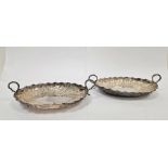 Pair of Victorian silver two-handled oval dishes, leaf and scroll engraving, each on four bun