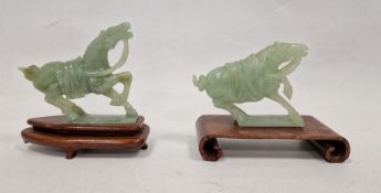 Two various carved jade horses, each with raised foreleg, 9cm high and the hardwood stands (some